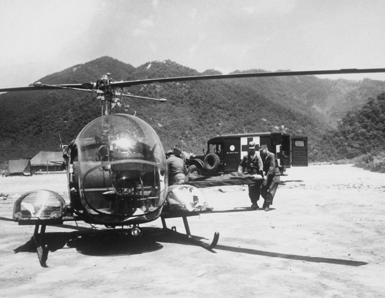 Medics_carry_wounded_soldier_to_H-13_helo_KOrea_1953.JPEG